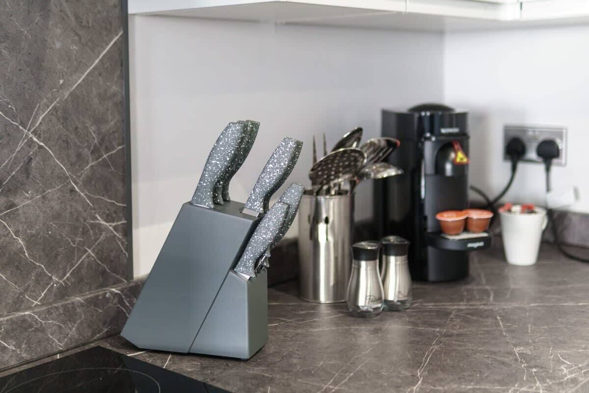 A kitchen counter with a knife block, a coffee maker, and a kettle.