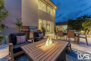 Un espace extérieur aménagé avec un patio, un foyer, des sièges et une table à manger.