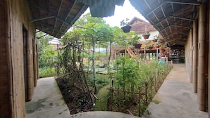 An indoor garden with a wooden structure, potted plants, and a concrete floor. - MUONG PHANG HOMESTAY (Muong Phang)