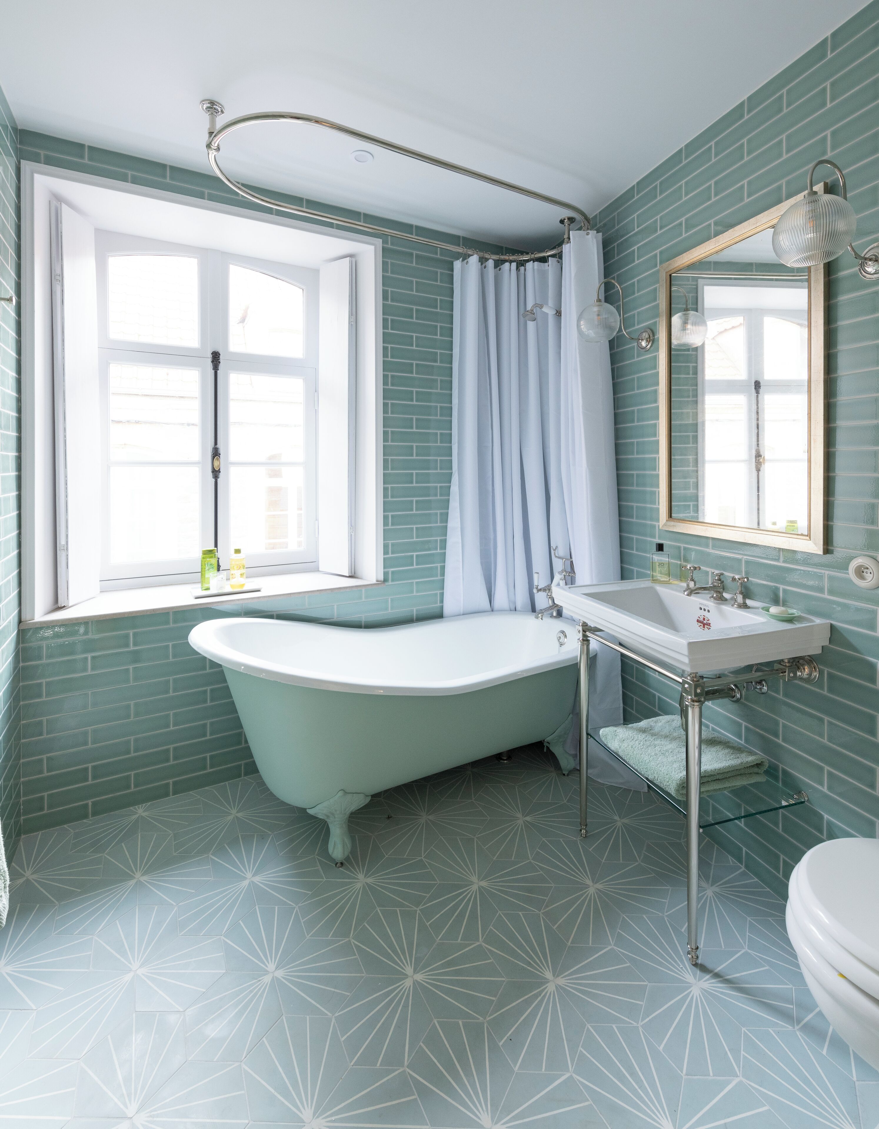 A bathroom with a freestanding bathtub, a sink, and a mirror.