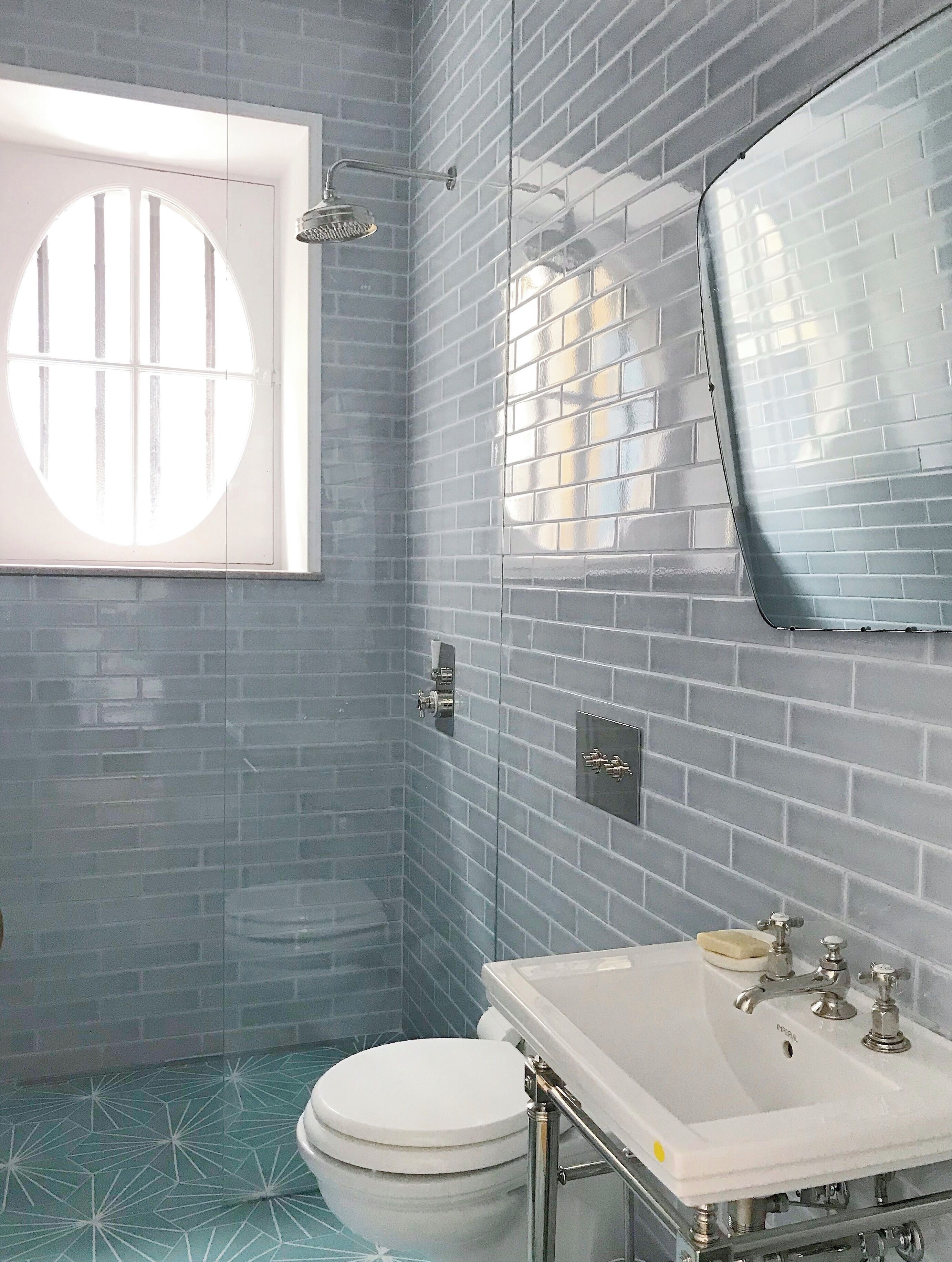 A bathroom with a white toilet, a sink with a mirror, and a shower.