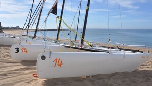 Several sailboats with numbers 14 and 3 14 on their sides, docked on a sandy beach with the sea in the background. - Renovated Cottage Near Marshes, 12 km from Beach, Private Terrace, Garden, WiFi, Baby-Friendly (Villeneuve-en-Retz)
