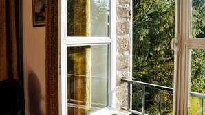 A room with a large window, a stone wall, and a wooden bench. - Belle Propriété au Calme, à la Campagne Avec Parc et Étangs (Le Mesnil-Véneron)