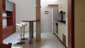 A kitchen with a dining area, including a table and chairs, and a built-in oven. - Cecchi Mansion (Nardò)