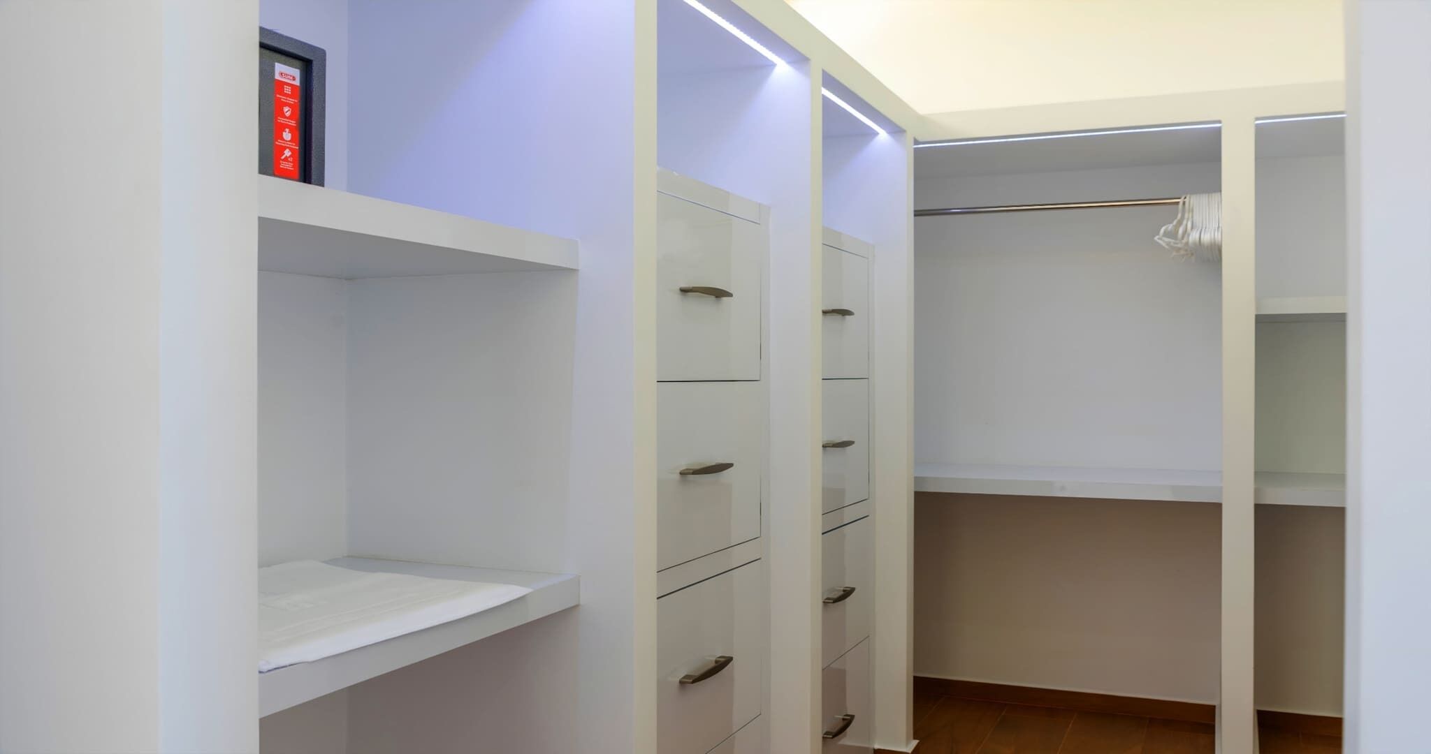 Un vestidor amplio con estantes abiertos, cajones y espacio para colgar.