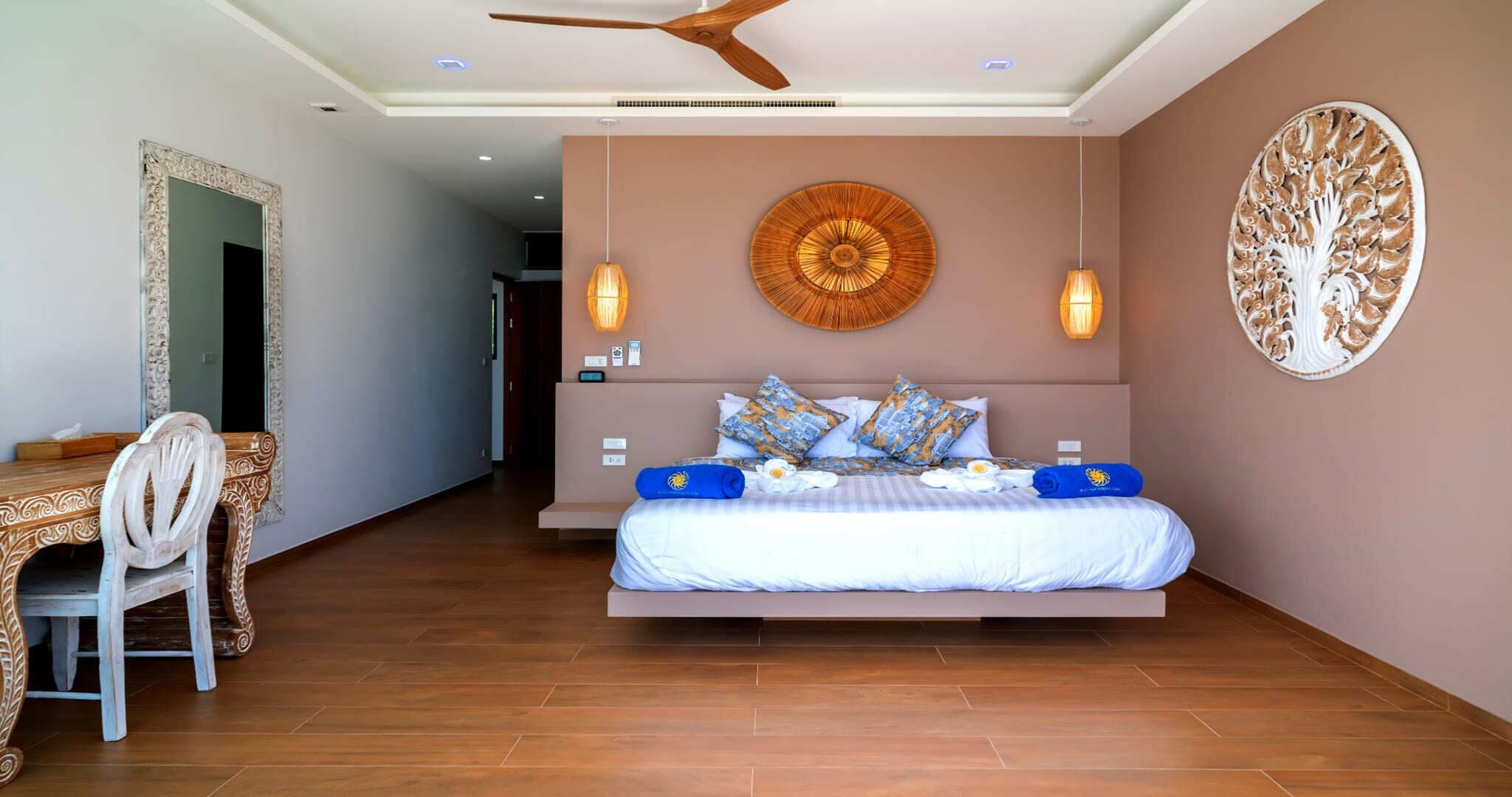 A modern hotel room with a large bed, a desk, and a chair.