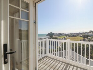 A balcony with a view of a coastal town, including a castle on a hill. - Haul A Gwynt (Criccieth)