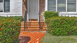 A house with a white door, brick steps, and a brick pathway leading to the entrance. - Garden Suites-Hosted by Sweetstay (Miami Beach)