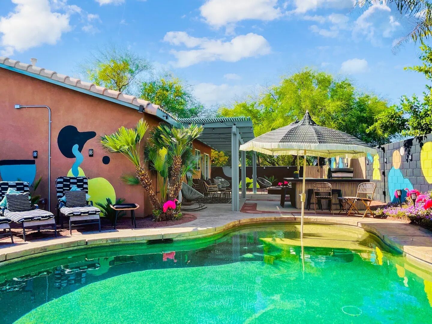 Una piscina con sillas de descanso y un pabellón.