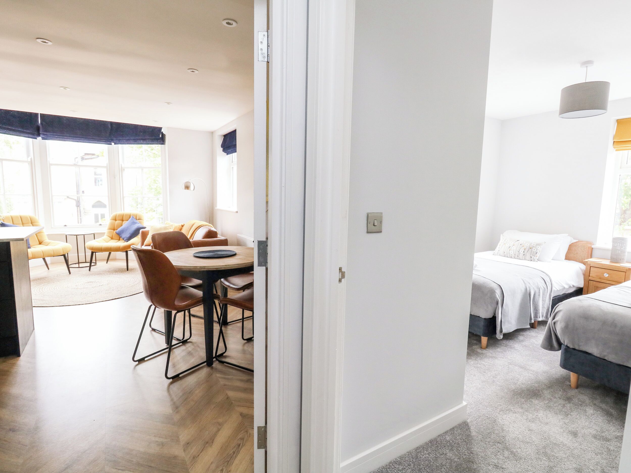 A modern room with a dining area, a bed, and a window.