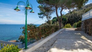 Une promenade en bord de mer agrémentée d’un muret en pierre, d’une clôture en bois et d’un lampadaire.