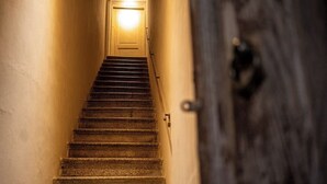 A staircase leading to a door with a light at the top. - 1 Bedroom Apartment in Caltagirone (Caltagirone)