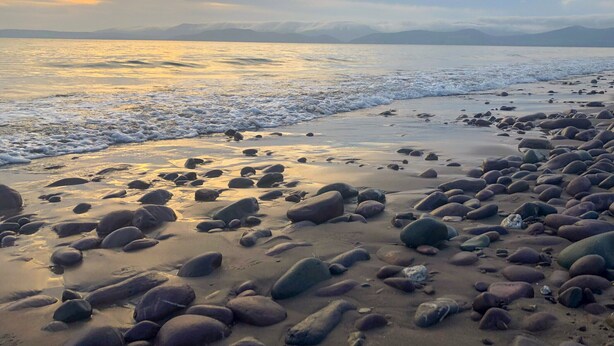 Une plage avec de gros rochers et des vagues.