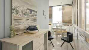 A modern kitchen with a dining area, featuring a large painting, a bowl, and a rabbit figurine on the counter. - Horizonte - Sea view by HD PROPERTIES (Quarteira)