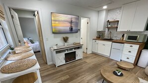 Una cocina moderna con armarios blancos, un microondas y un horno empotrado.