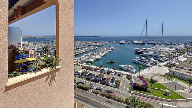 A marina with numerous boats docked, a clear blue sky, and a view of the sea. - (102) Le superbe au Palais (Vallauris)