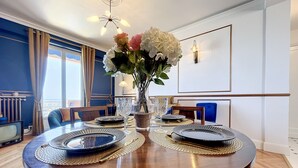 A dining table set with plates, glasses, and a vase of flowers. - (102) Le superbe au Palais (Vallauris)