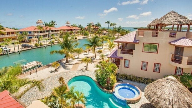 A resort with multiple buildings, a central swimming pool, and a smaller hot tub. - Magnificent Belize Townhouse-Pool-Private Island (Placencia)