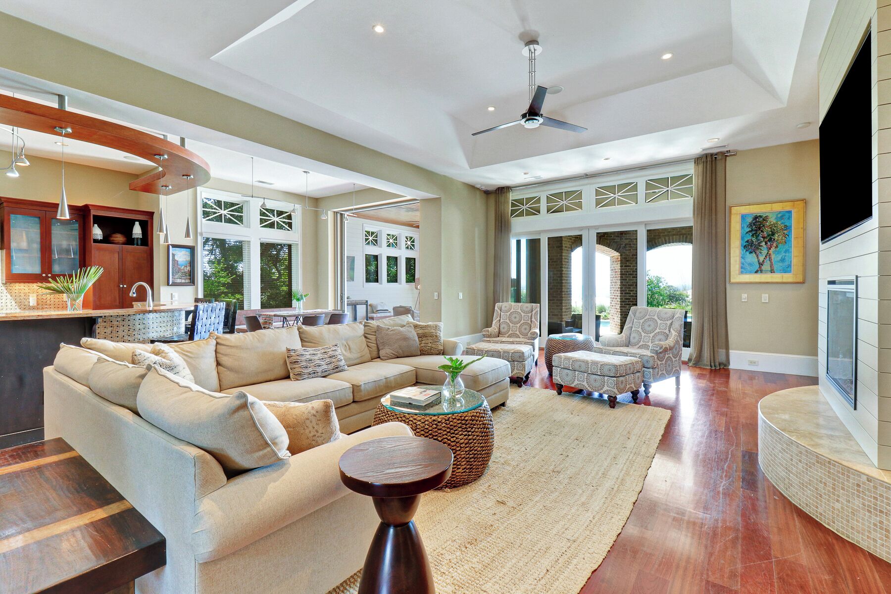 A spacious living room with a sectional sofa, a coffee table, and patterned armchairs.