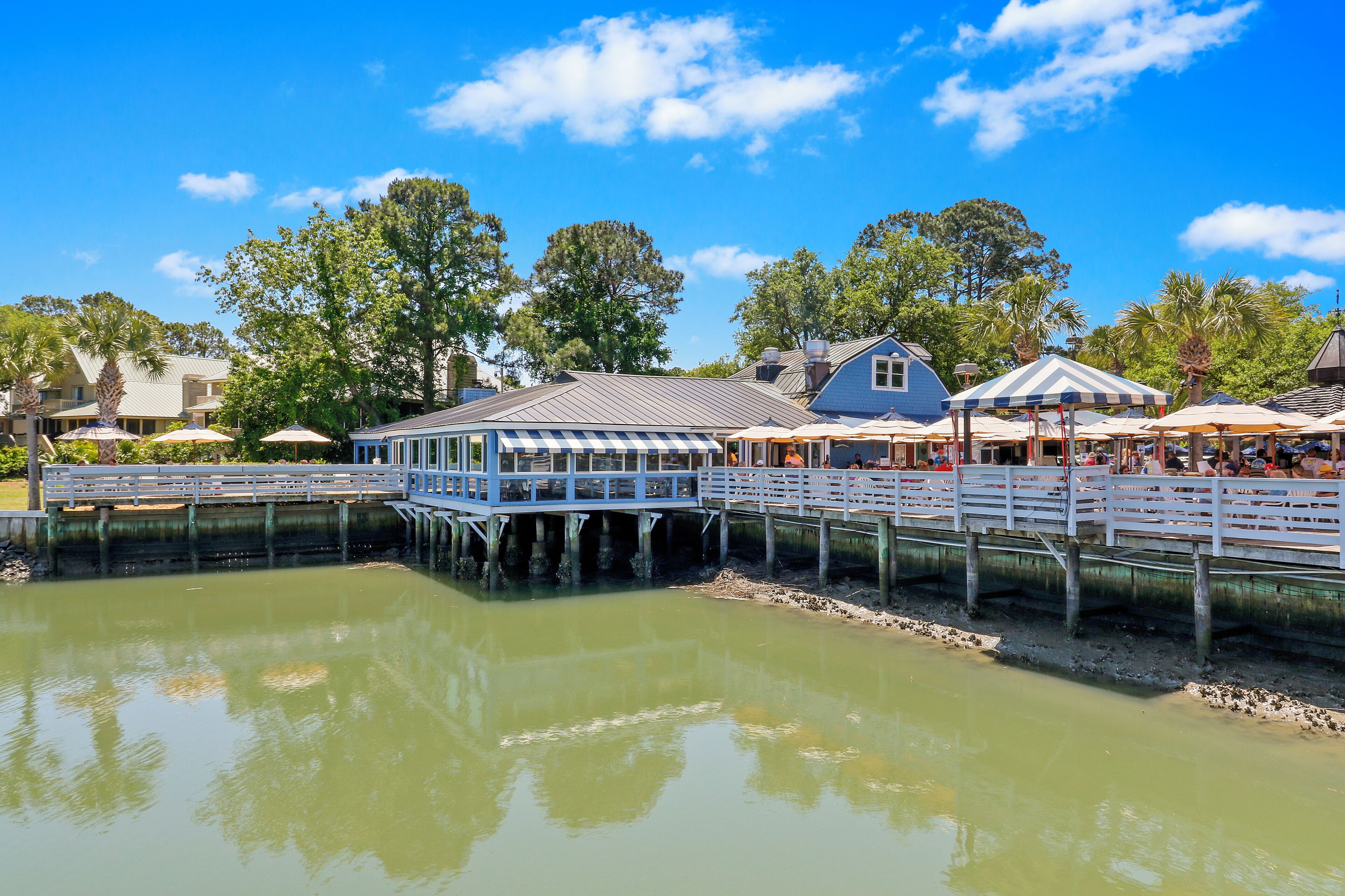 A waterfront property with a dock, a covered pavilion, and a house.