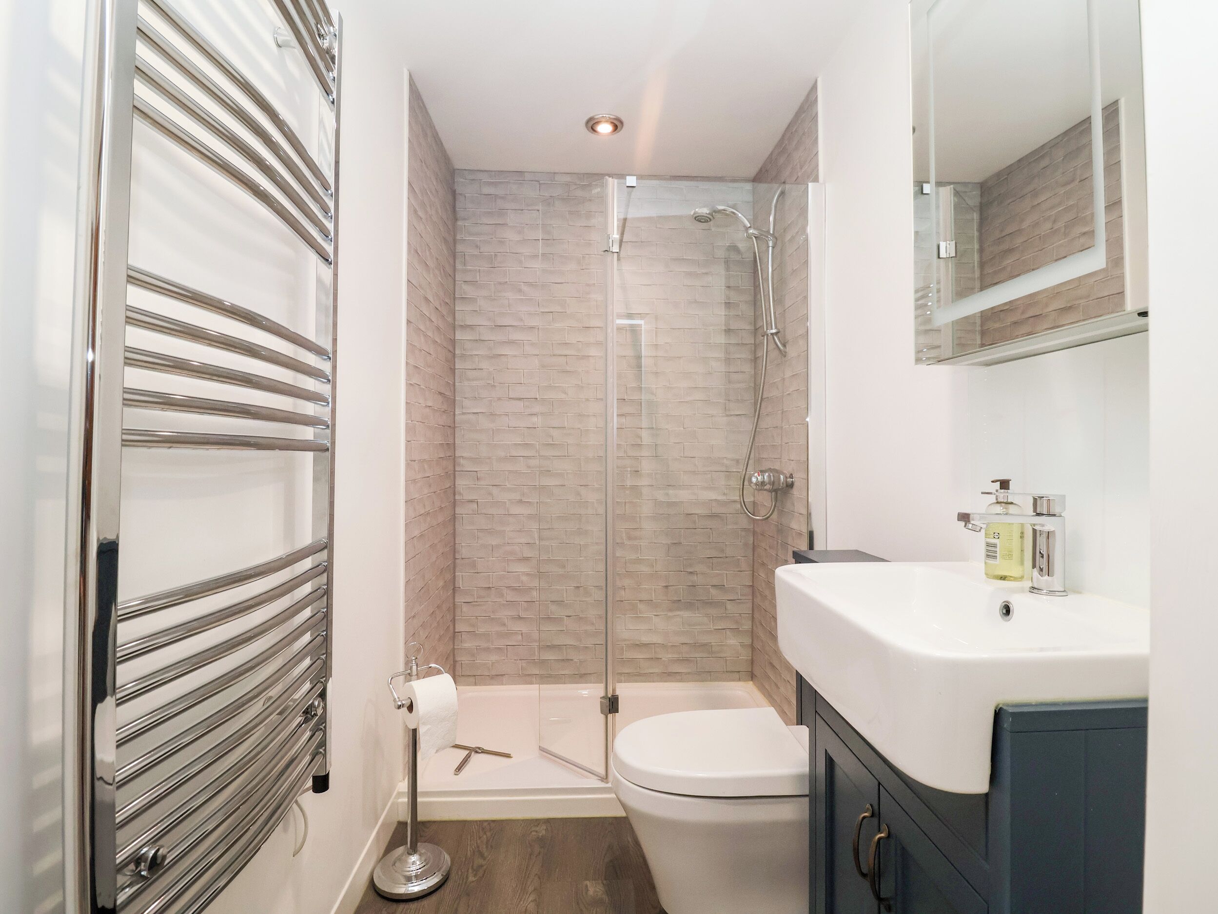 Une salle de bain moderne équipée d’une douche, de toilettes et d’un lavabo.
