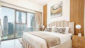 Un dormitorio moderno con una cama grande, una mesita de noche, una lámpara y vistas a la ciudad.