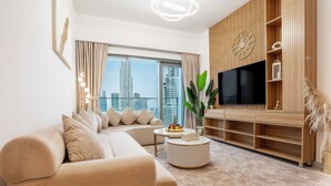 Una sala de estar moderna con un sofá, una mesa de centro, un televisor y un ventanal con vistas a la ciudad.