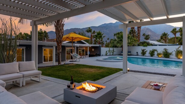 A modern outdoor patio with a fire pit, seating, and a pool. - Enchanting Escudero - Luxury PS Ranch Home! (Palm Springs)