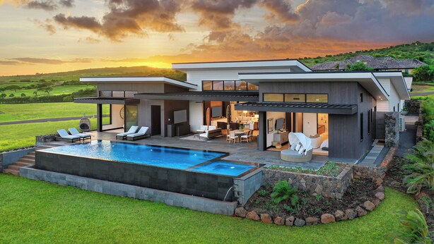 A modern two-story house with a swimming pool, outdoor seating, and a view of the countryside. - Hale Mahina Hou: Luxe 4BR Home w/ Ocean Views, Infinity Pool & Outdoor Seating (Koloa)