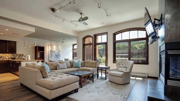 A modern living room with a sectional sofa, a coffee table, and a fireplace. - Sprawling Condo | Central Downtown | Free Shuttle (Steamboat Springs)