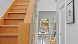 A wooden staircase with a glass railing leading to a second floor.