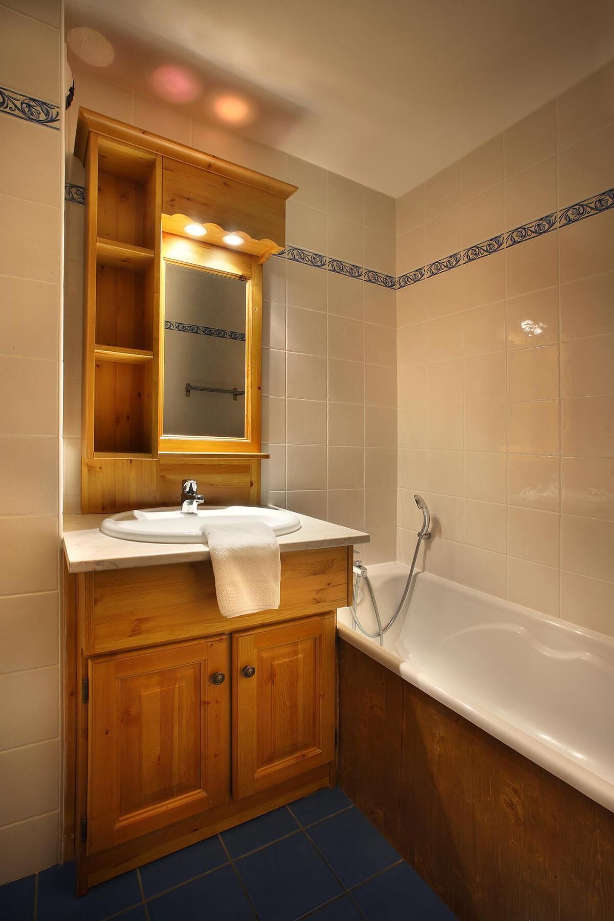 A bathroom with a wooden vanity, two sinks, a mirror, and a bathtub.