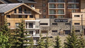 A multi-story hotel with wooden facades and a stone building labeled "DIA-HYSTR". - Wifi, 150m from ski slopes, fitness, swimming pool, sauna, hammam, balcony, 63m², Alpe d'Huez (L'Alpe d'Huez)