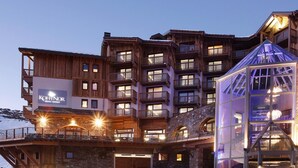 Ein mehrstöckiges Hotel mit Balkonen und einer Glasarchitektur.