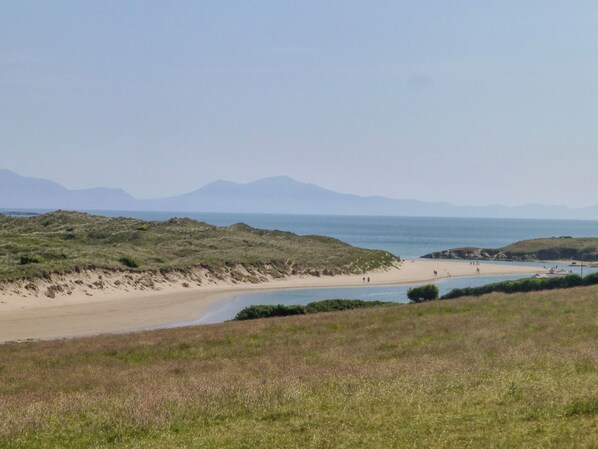 A beach with grassy dunes, a sandy beach, and a calm sea. - Morlais (Ty Croes)