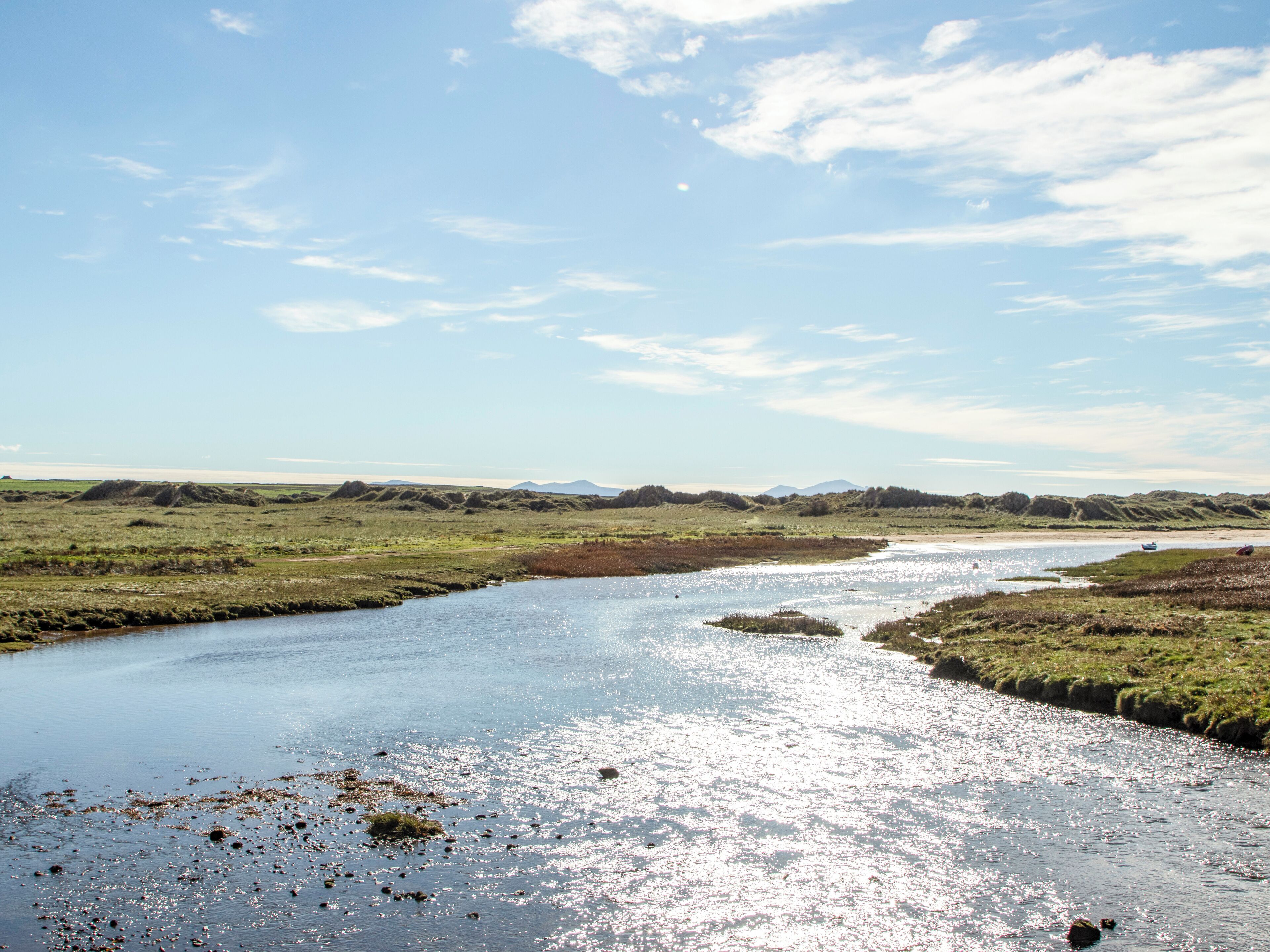 A river meandering through a flat landscape with distant hills.