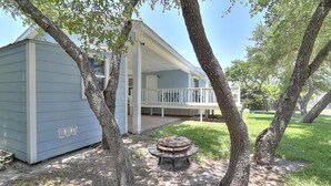 A single-story building with a covered porch and a small outdoor seating area. - Seashell Memories (Rockport)