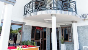 Un edificio con un espacio al aire libre techado que cuenta con mesa de billar, balcón con barandilla y un letrero de 'CINNABONI'.