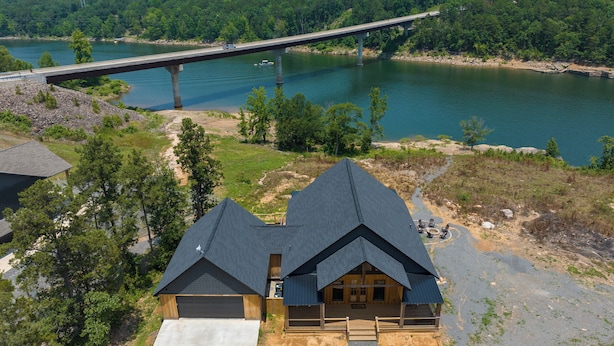 A cabin with a large deck and a view of a bridge over a river.