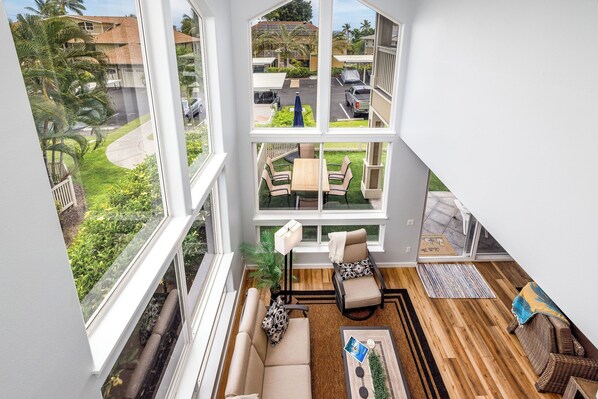 Een modern appartement met een groot balkon, een houten vloer en uitzicht op een woonwijk.