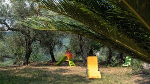 A playground with a slide and swings, surrounded by trees. - Apartment Ulivo by Interhome (Chiusanico)