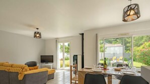 Un salon moderne avec un canapé, un téléviseur et un coin repas.