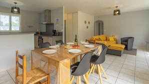 Une cuisine moderne avec un coin repas, un canapé et un fauteuil.