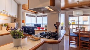 A modern kitchen with a central island, wooden cabinetry, and a view to the outside.