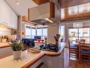 Een koelkast, een microgolfoven, een oven, kookgerei, borden en bestek