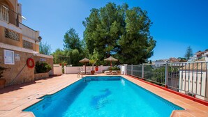 A rectangular swimming pool with clear blue water, surrounded by a tiled deck and a metal fence. - Apartment Velez by Interhome (Nerja)