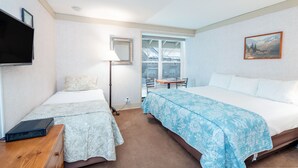 Een hotelkamer met twee bedden, een televisie, een bureau en een raam met uitzicht.