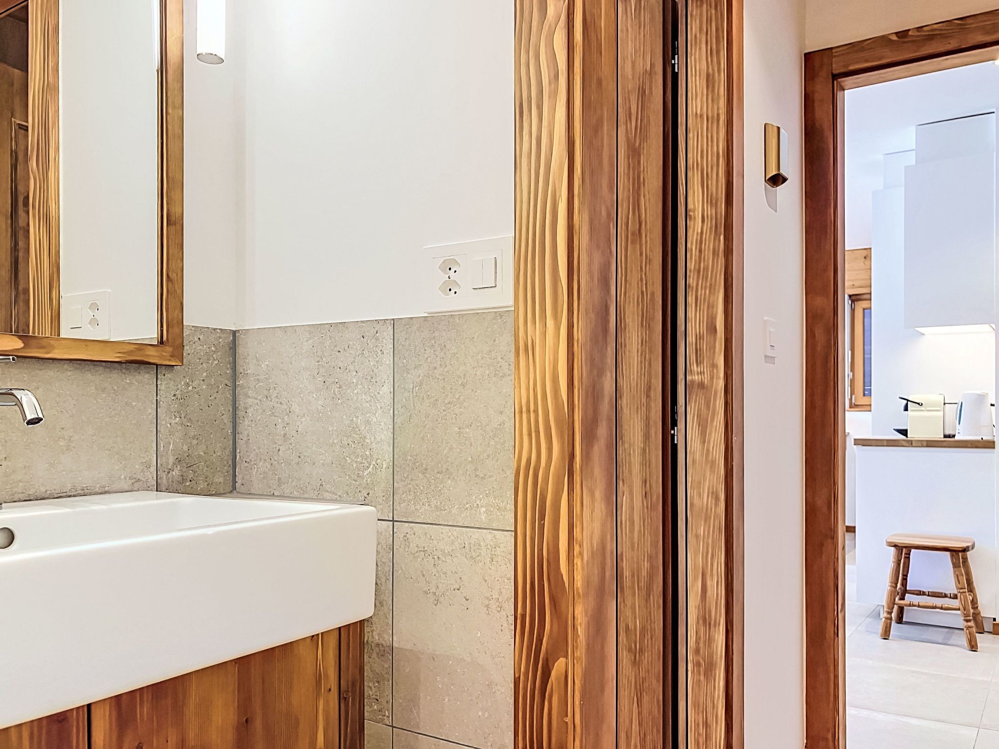 A bathroom with a wooden vanity, a sink, and a mirror.