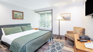 A hotel room with a bed, a desk, a chair, a lamp, and a TV. - Mountainside Inn 113 1 Bedroom Condo by Alpine Lodging Telluride (Telluride)