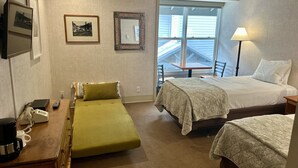 A hotel room with two beds, a desk with a telephone, a lamp, and a window with a view of the outside. - Mountainside Inn 214 1 Bedroom Hotel Room by Alpine Lodging Telluride (Telluride)